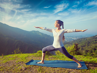 Image showing Woman doing yoga asana Virabhadrasana 2 - Warrior pose outdoors