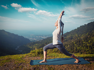 Image showing Woman doing yoga asana Virabhadrasana 1 - Warrior pose outdoors