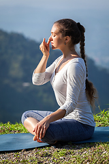 Image showing Woman practices pranayama in lotus pose outdoors