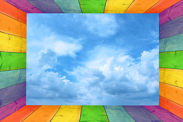Image showing multicilored frame on the cloudy blue sky background