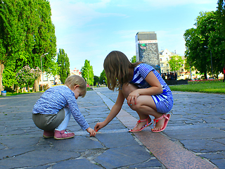 Image showing little sisters write on the road in the park