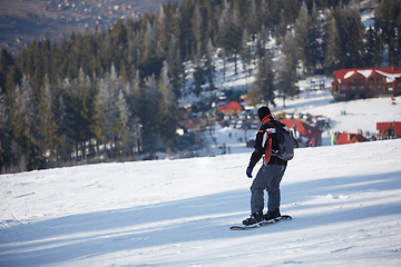 Image showing Man snowboarder rides on the slope. ski resort. Space for text