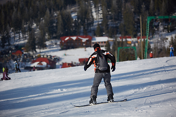 Image showing Man snowboarder rides on the slope. ski resort. Space for text