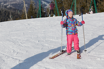 Image showing A happy little girl off skiing with slides