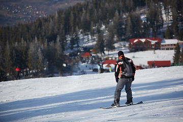 Image showing Man snowboarder rides on the slope. ski resort. Space for text