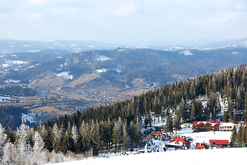 Image showing Beautiful colorful landscape. The ski resort with a background of a small residential area surrounded by trees.