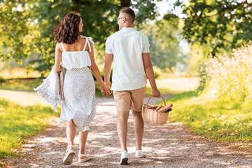 Image showing happy couple with picnic basket at summer park