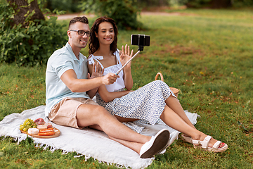 Image showing happy couple taking selfie at picnic in park