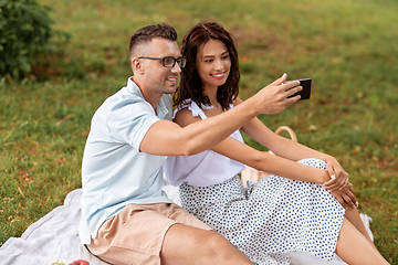 Image showing happy couple taking selfie at picnic in park