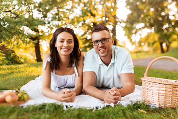 Image showing happy couple on picnic blanket at summer park