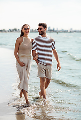 Image showing happy couple walking along summer beach