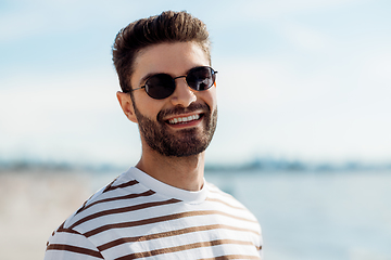 Image showing smiling young man in sunglasses on summer beach