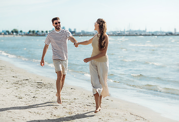 Image showing happy couple running along summer beach