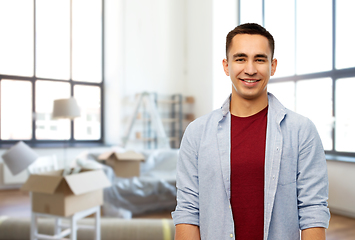 Image showing smiling young man over new home background