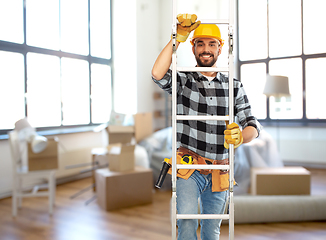 Image showing male builder in helmet climbing up ladder at home