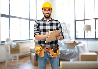 Image showing male builder in helmet with clipboard at home