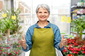 Image showing senior woman showing thumbs up in gardening center