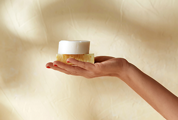 Image showing hand holding bar of craft soap on beige background