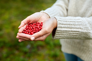 Image showing close up of young woman holding berries in hands