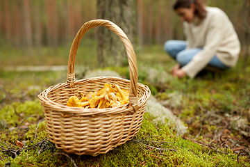 Image showing young woman picking mushrooms in autumn forest