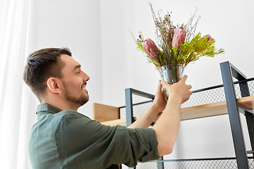 Image showing man decorating home with flowers in vase