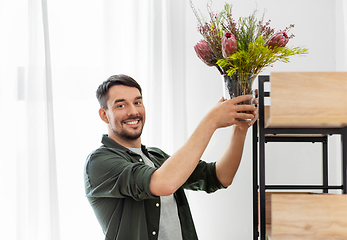 Image showing man decorating home with flower or houseplant