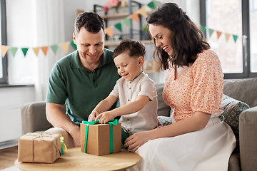 Image showing happy family opening birthday presents at home