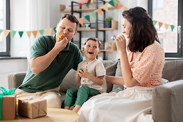 Image showing happy family with gifts and party blowers at home