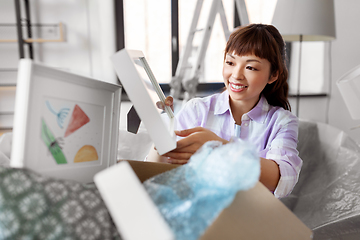 Image showing happy woman unpacking boxes and moving to new home