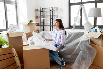 Image showing woman with blueprint and boxes moving to new home