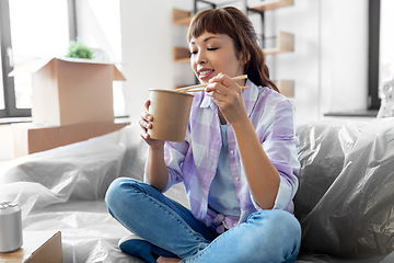 Image showing happy woman moving to new home and eating wok