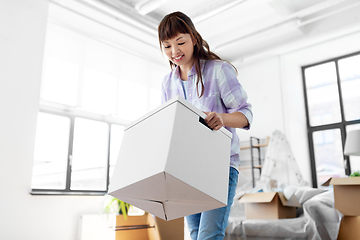 Image showing happy woman unpacking boxes and moving to new home