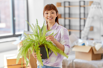 Image showing happy woman with fern flower moving to new home