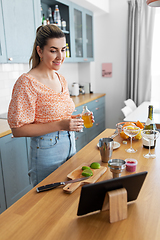 Image showing woman with tablet pc making cocktails at kitchen