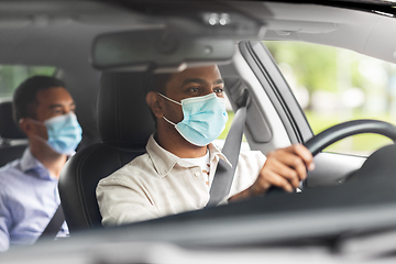 Image showing male driver in mask driving car with passenger