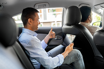 Image showing man with tablet pc having video call in taxi car