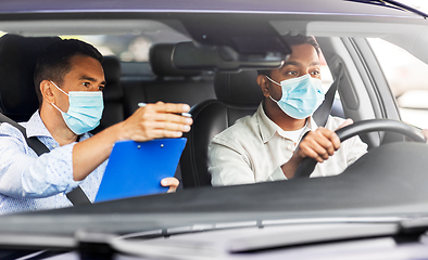 Image showing car driving school instructor and driver in mask