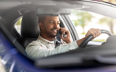 Image showing indian man driving car and calling on smartphone