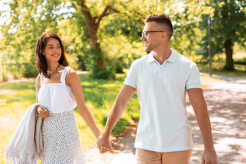 Image showing happy couple with picnic blanket at summer park