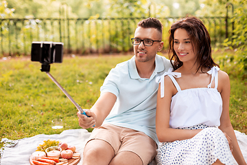 Image showing happy couple taking selfie at picnic in park