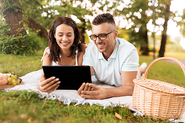 Image showing happy couple with tablet pc at picnic in park