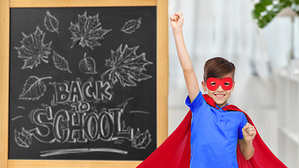 Image showing boy in super hero costume over school blackboard