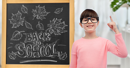 Image showing little student girl in glasses pointing finger up