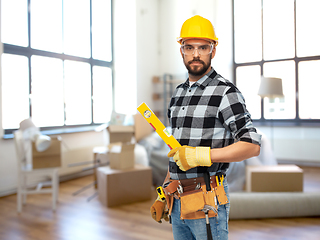 Image showing male builder in helmet with level at home