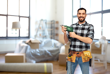 Image showing happy male builder with drill and tools at home