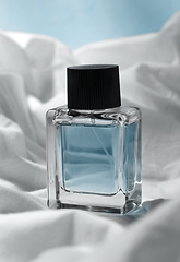 Image showing bottle of perfume on white sheet