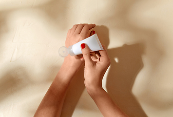 Image showing female hands applying moisturizer to skin