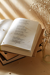 Image showing books and decorative dried flowers in glass bottle