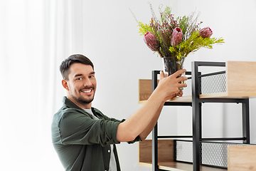 Image showing man decorating home with flower or houseplant