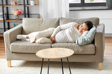 Image showing happy pregnant asian woman lying on sofa at home